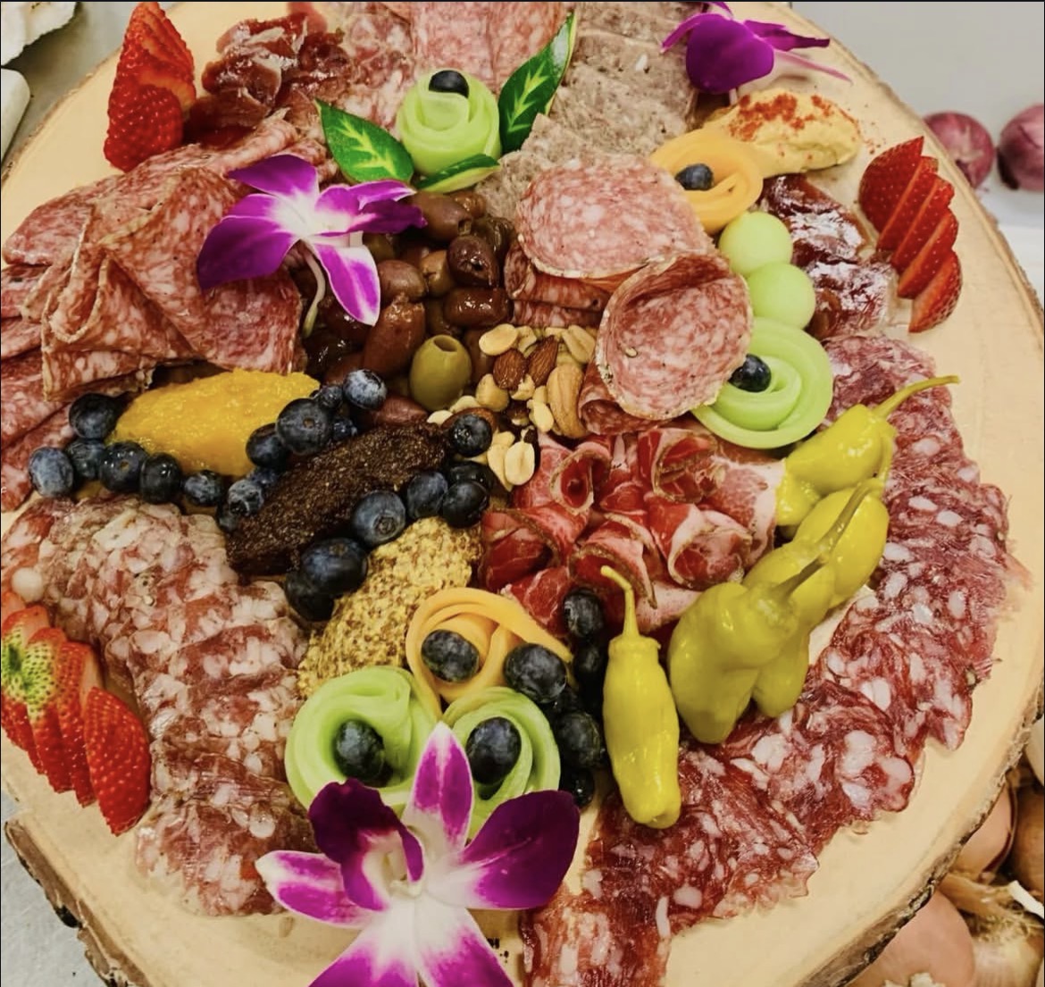 Abundant charcuterie board with fruit and flowers